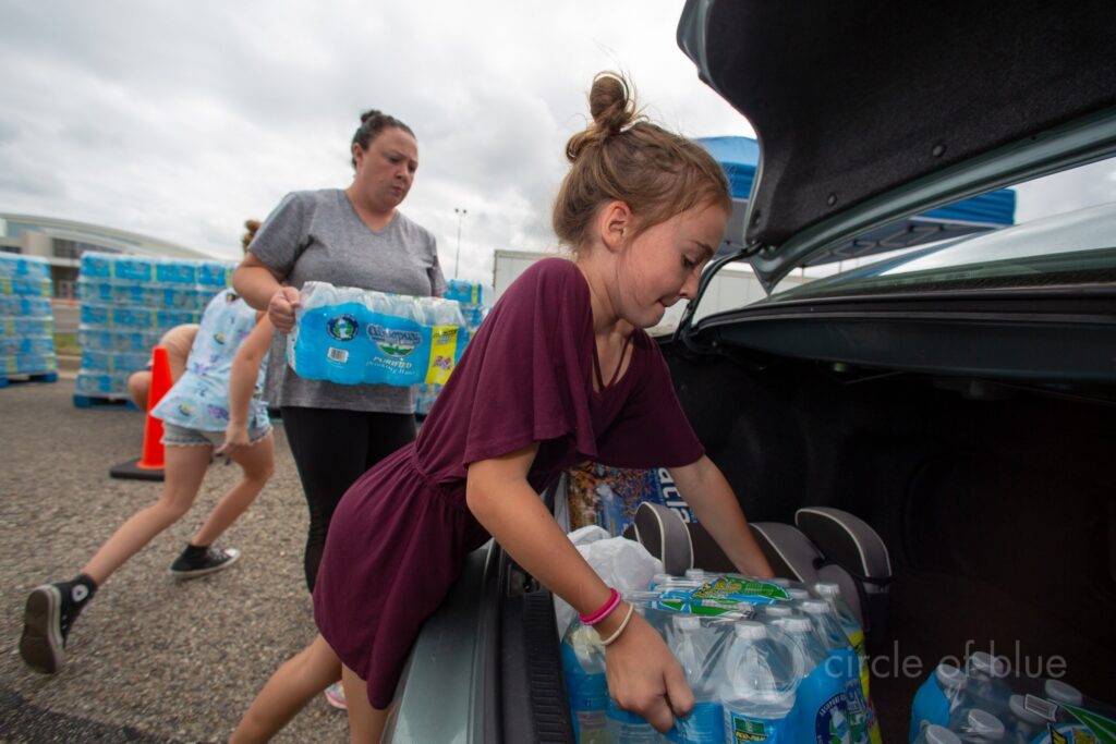 Residents in Parchment, Michigan, pick up bottled water in August 2018 after high levels of PFAS chemicals were found in the town’s wells. Photo © J. Carl Ganter/Circle of Blue