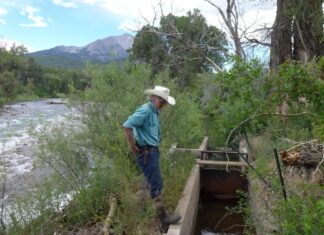 Crystal River rancher Bill Fales stands at the headgate for the Helms Ditch photo